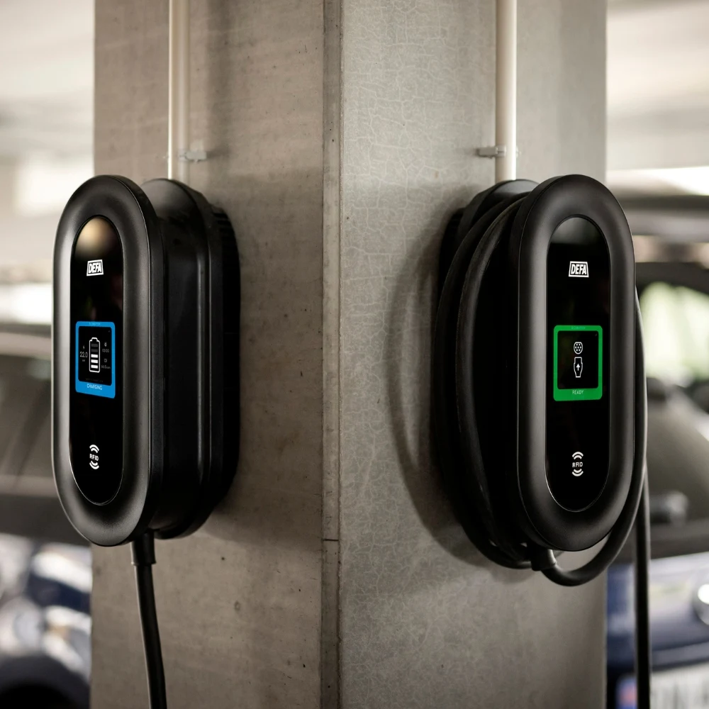 Flera Defa Power laddboxar installerade på en vägg i en parkeringsanläggning.