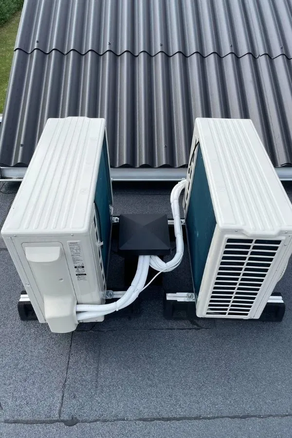Två utomhusdelar för luftvärmepumpar installerade sida vid sida för att täcka ett större uppvärmningsbehov.