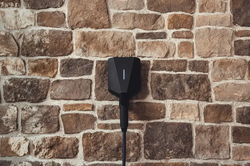Easee Charge Up laddbox monterad på en stenfasad.