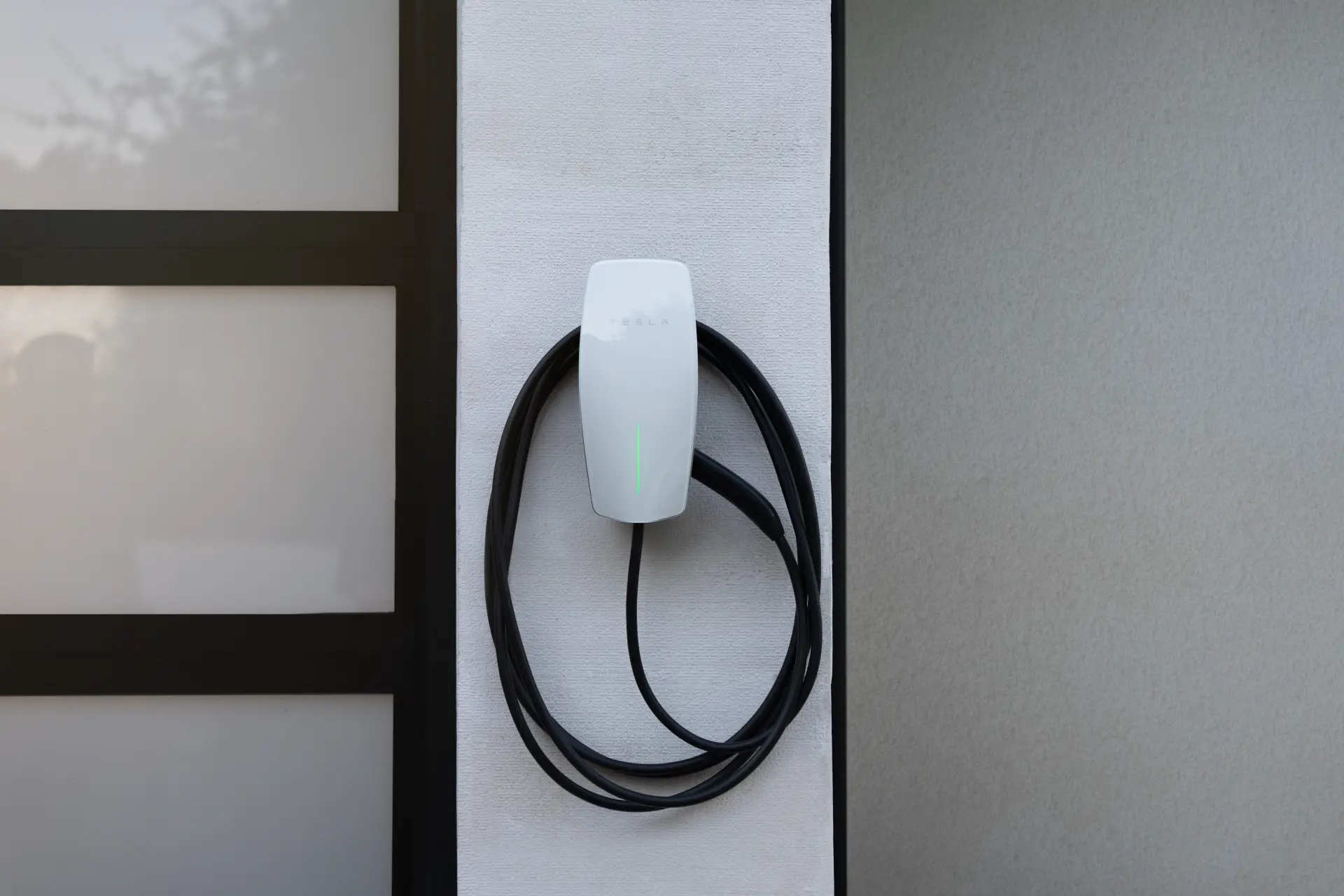 En Tesla Wall Connector laddbox installerad och redo för användning i en hemmiljö.