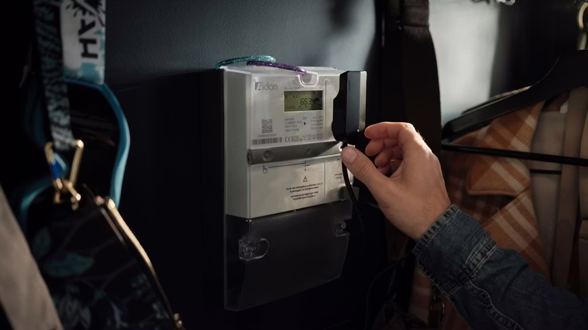 Närbild på en Tibber Pulse ansluten till en elmätare för smart lastbalansering i realtid.