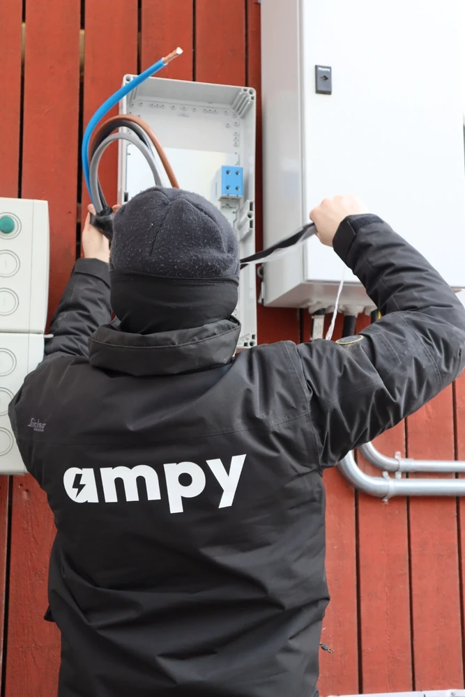 Närbild på en elektriker som installerar en Solis S6 växelriktare på en vägg.