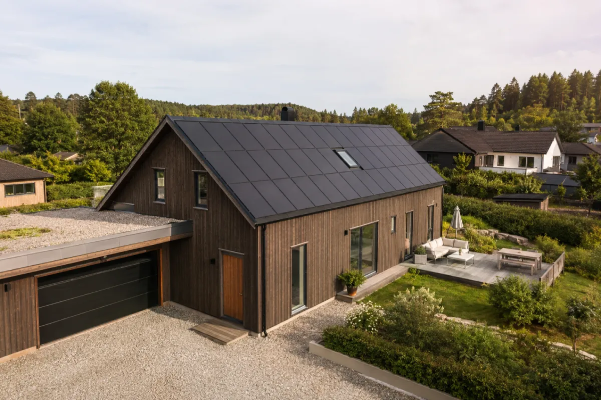 Modern wooden house with solar panels and green roof.