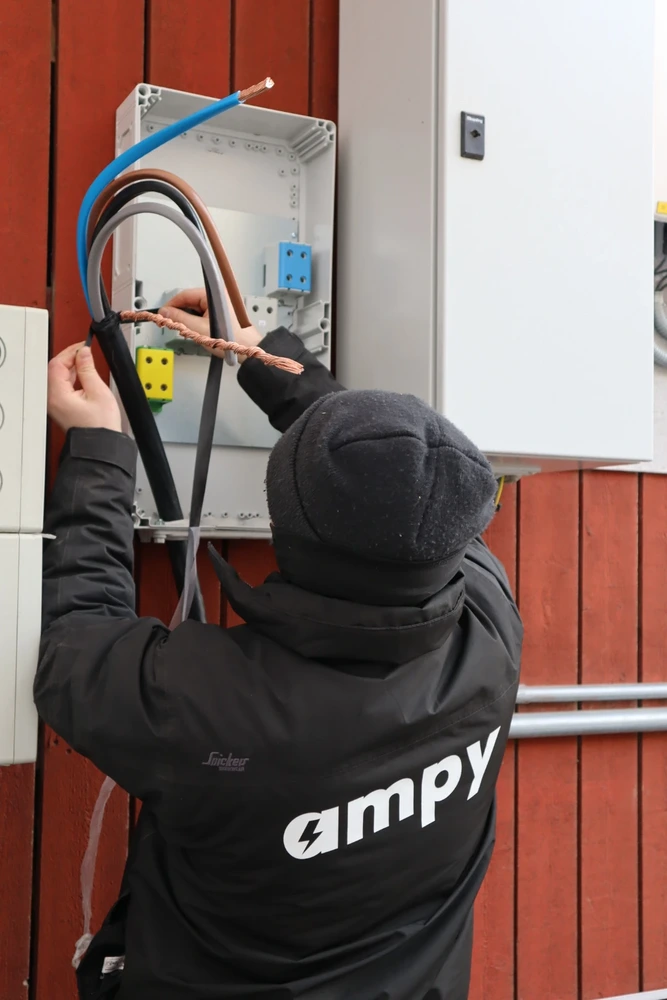 En Ampy-elektriker som monterar och ansluter en växelriktare, en vital del av batterilagringen.