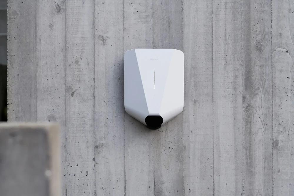 En vit Easee Charge Up laddbox installerad på en vägg.